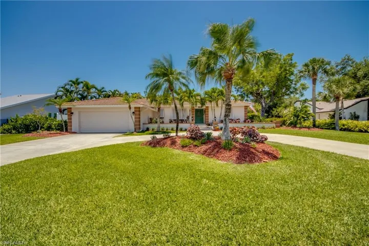 View of front of property featuring a front yard and a garage