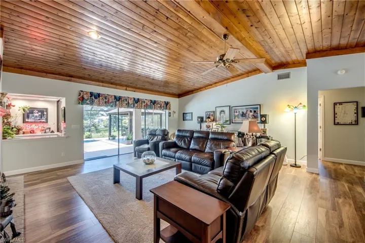 Living room with wooden ceiling, wood-type flooring, ceiling fan, and vaulted ceiling