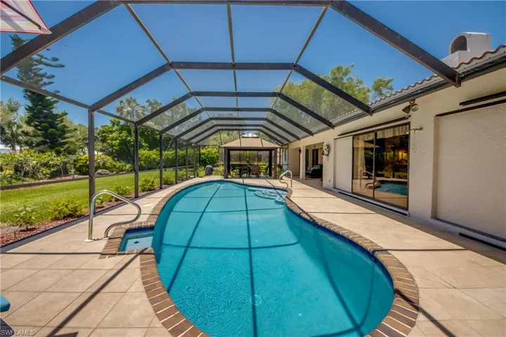 View of swimming pool with a lanai and a patio