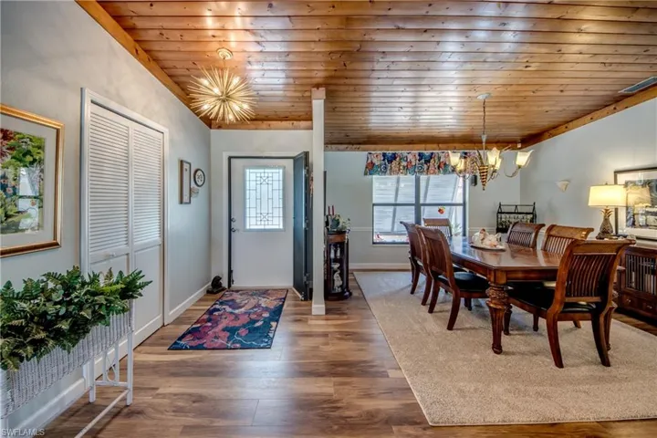 Dining area featuring an inviting chandelier, hardwood / wood-style floors, and wood ceiling