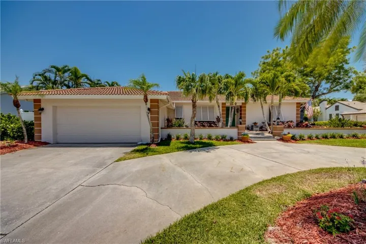 View of front of home with a garage and circular driveway