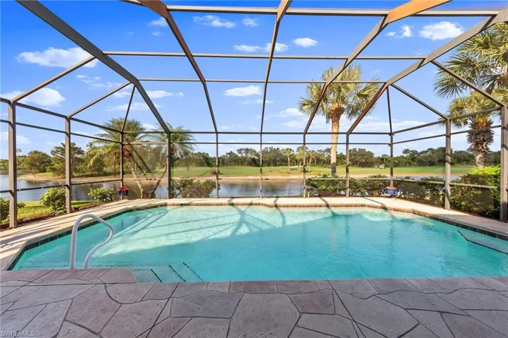 Swimming pool featuring a sunroom, a lanai, a water view, and a patio area
