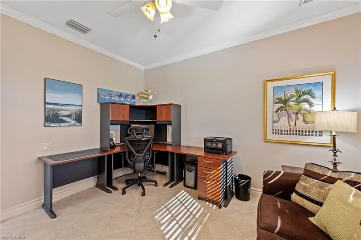 Office area with ornamental molding, light tile patterned floors, and ceiling fan
