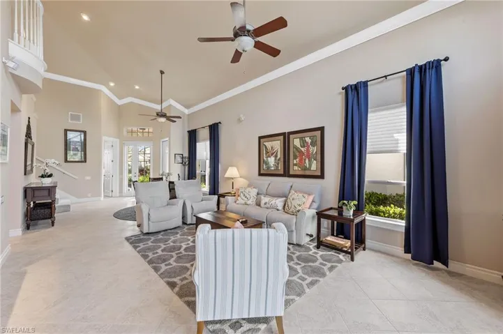 Living room with high vaulted ceiling, ornamental molding, a ceiling fan, recessed lighting, and light tile patterned flooring