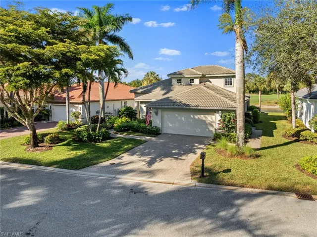 Mediterranean / spanish house featuring decorative driveway, a front yard, a tile roof, and a garage