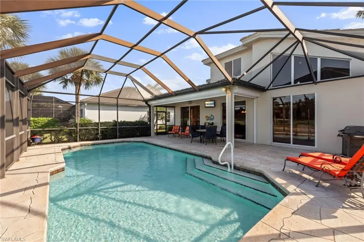 Swimming pool featuring a patio, a sunroom, a lanai, and a grill