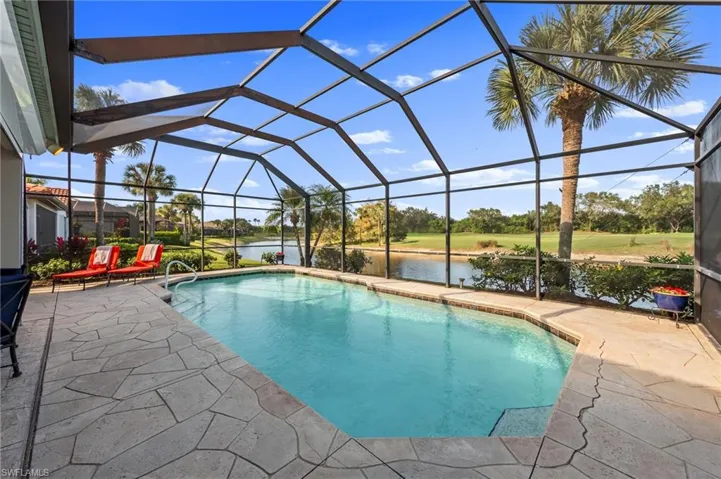 Outdoor pool with a sunroom, a water view, a patio area, and glass enclosure