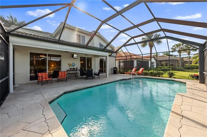 Swimming pool with a sunroom, a patio, and glass enclosure