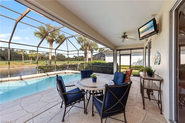 View of patio featuring a sunroom, glass enclosure, ceiling fan, an outdoor pool, and outdoor dining area