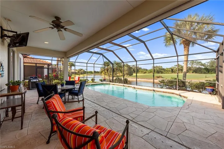 Outdoor pool featuring a sunroom, a lanai, a patio area, a water view, and grilling area