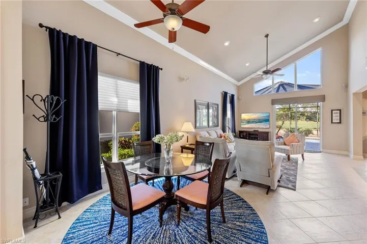 Dining space featuring high vaulted ceiling, ornamental molding, and a ceiling fan