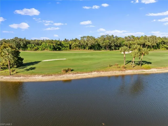 Water view featuring a tree filled landscape and a golf club