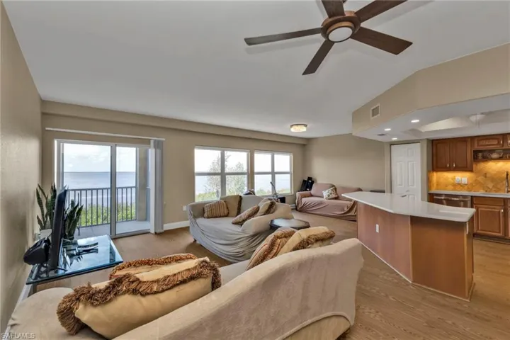 Living room featuring ceiling fan, a healthy amount of sunlight, and light wood-type flooring