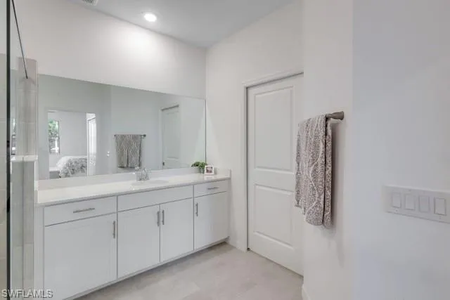 Bathroom with vanity, connected bathroom, and a shower with shower door