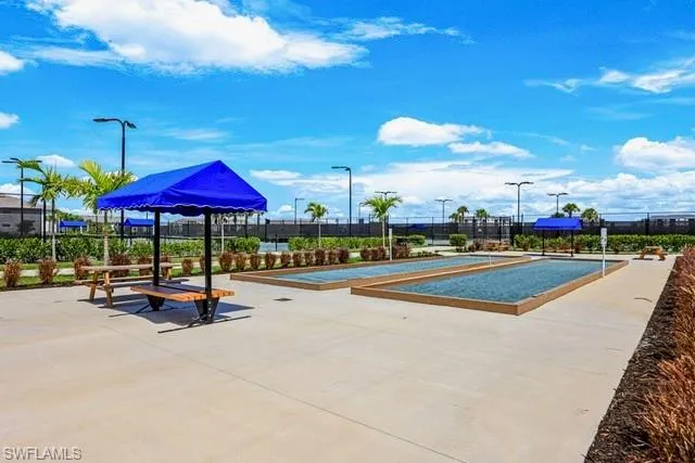 View of community with a bocce ball area and fence