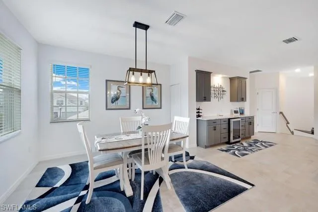 Dining room featuring beverage cooler, baseboards, and bar