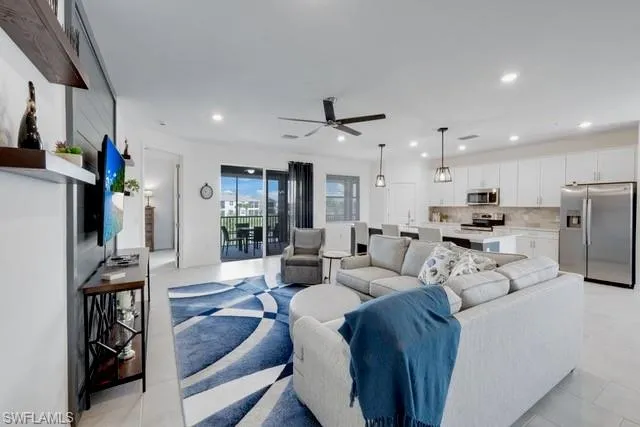 Living room featuring recessed lighting, ceiling fan, and light tile patterned floors