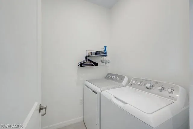 Laundry area featuring separate washer and dryer and baseboards