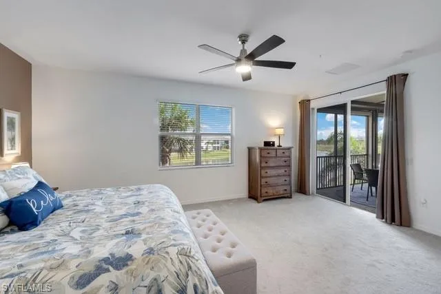 Bedroom featuring access to outside, multiple windows, and light colored carpet