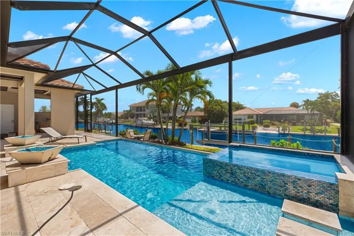 View of pool featuring a patio, an in ground hot tub, and glass enclosure