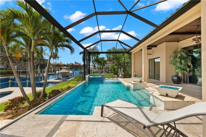 View of pool with a patio area, an in ground hot tub, ceiling fan, and glass enclosure