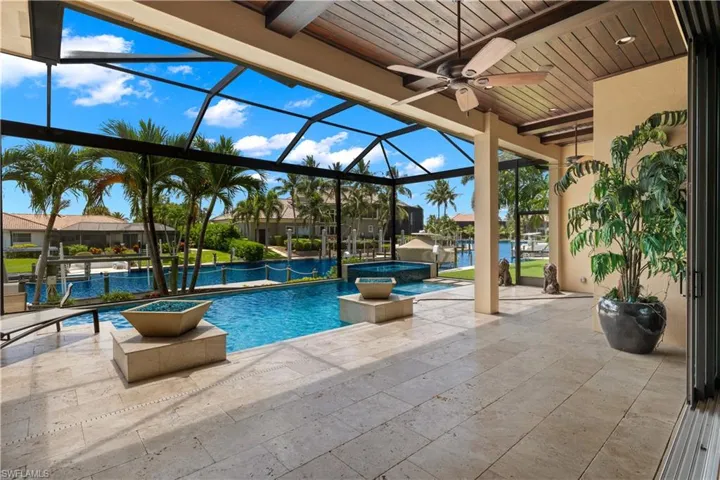 View of pool with a lanai, a patio, and ceiling fan