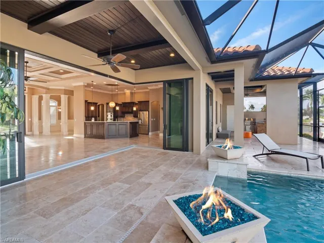 View of pool with an outdoor fire pit, a patio, a lanai, and ceiling fan