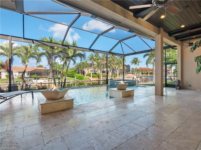 View of swimming pool featuring ceiling fan and a lanai