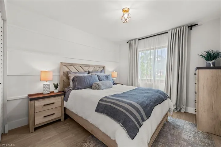 Bedroom with wood finished floors and baseboards