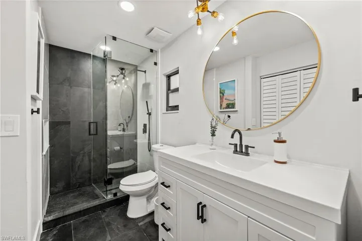 Bathroom with vanity, a stall shower, and recessed lighting