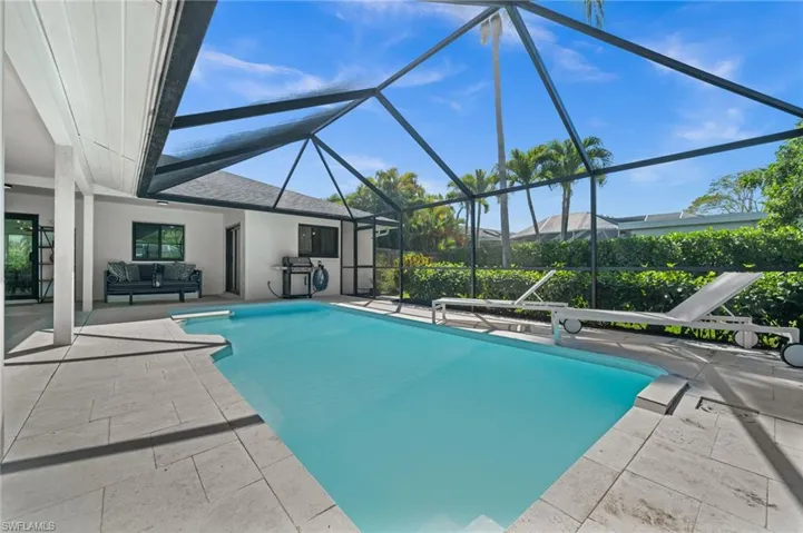 Swimming pool featuring a patio area, a sunroom, glass enclosure, and outdoor lounge area