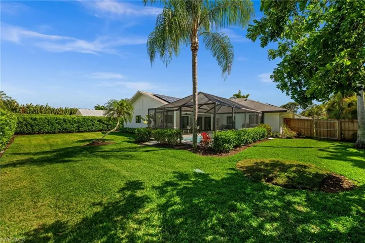 Rear view of house featuring a sunroom, a lanai, a fenced backyard, an outdoor pool, and stucco siding
