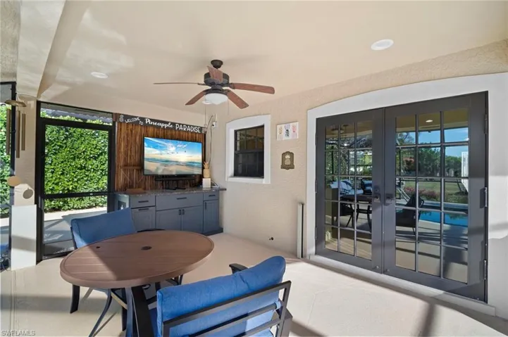Sunroom featuring an outdoor kitchen / dining area, ceiling fan, french doors, and a patio