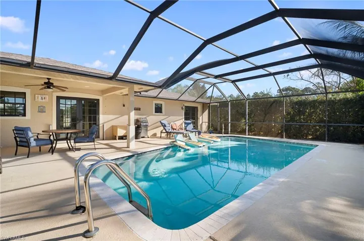 Swimming pool with a sunroom, a lanai, a patio area, and outdoor dining space