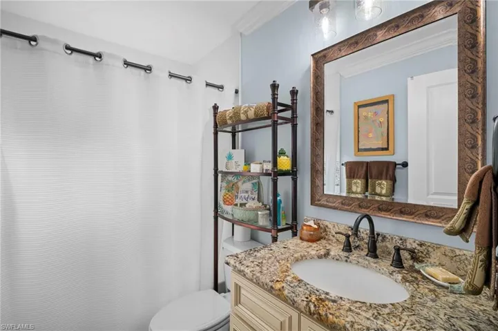 Bathroom featuring vanity, curtained shower, and crown molding