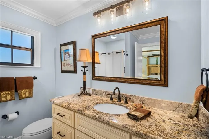 Bathroom featuring crown molding, vanity, and a shower with shower curtain