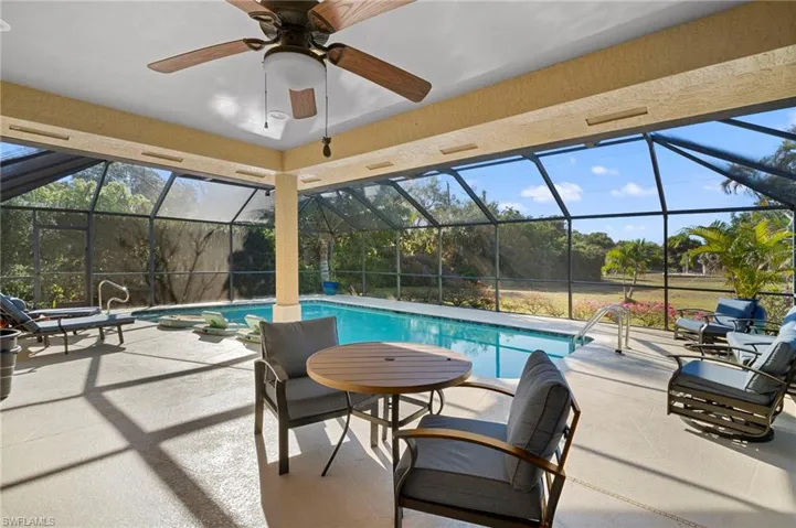 Swimming pool with glass enclosure, a patio, and a sunroom