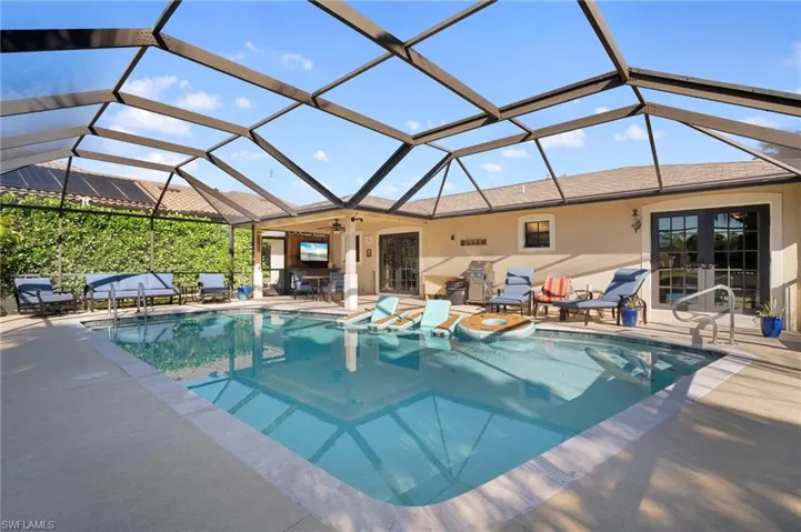 Swimming pool with french doors, a sunroom, a patio area, and glass enclosure