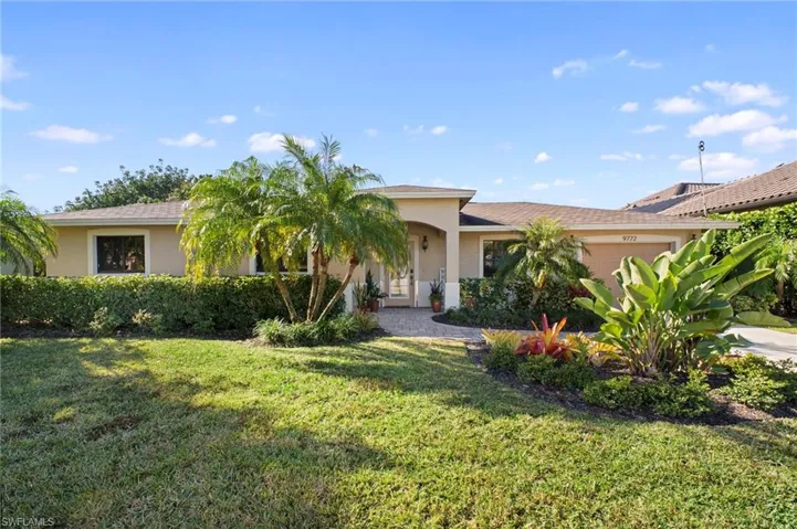 Ranch-style home with stucco siding, a garage, a front lawn, and driveway