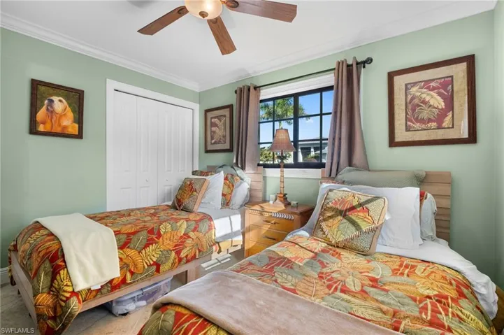 Bedroom with a closet, crown molding, and ceiling fan