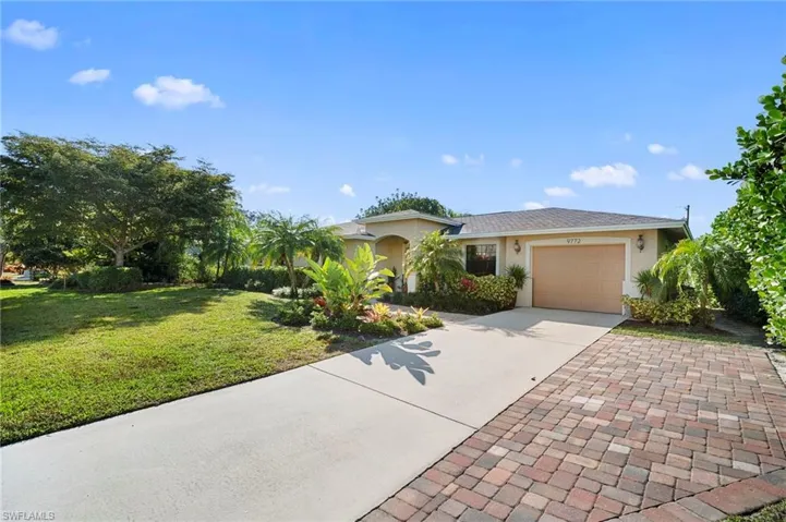 Ranch-style home featuring driveway, stucco siding, a garage, and a front yard