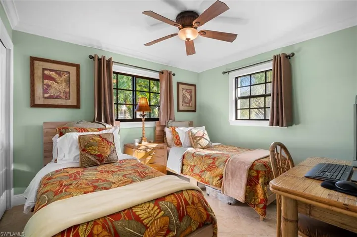 Bedroom featuring crown molding, multiple windows, ceiling fan, and an office area