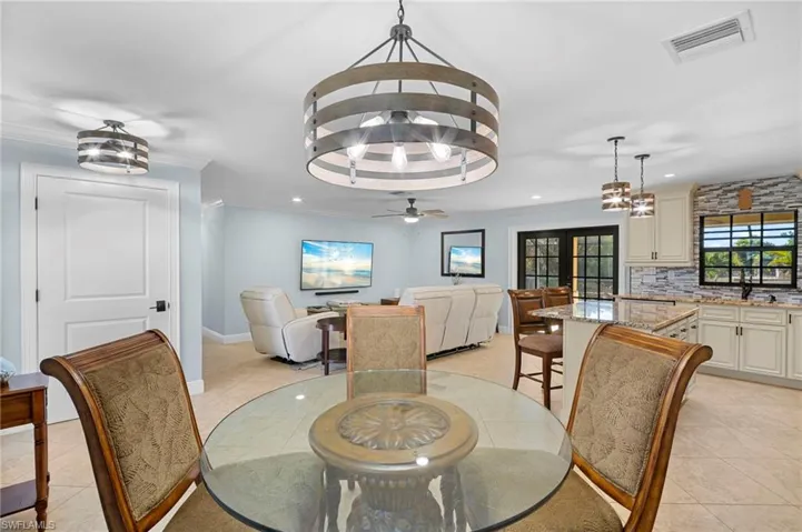 Dining space featuring a chandelier, light tile patterned flooring, ceiling fan, and crown molding