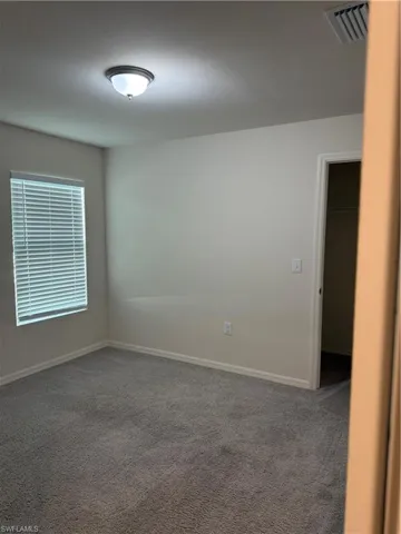Empty room with carpet floors and baseboards