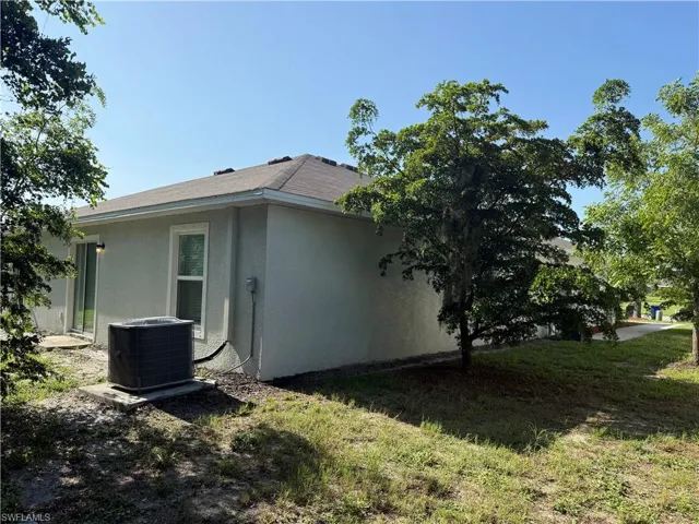 View of side of home featuring a central air condition unit and stucco siding