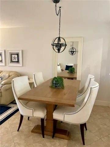Dining area featuring light tile patterned floors and a chandelier