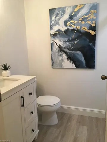 Half bathroom with vanity and light wood-type flooring