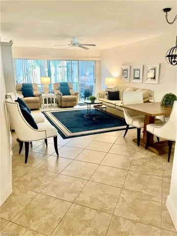 Living area featuring light tile patterned floors and ceiling fan