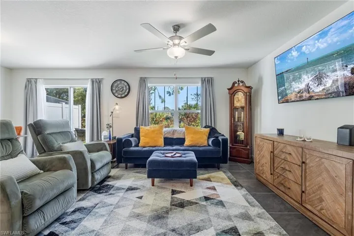 Tiled living room with a textured ceiling and ceiling fan