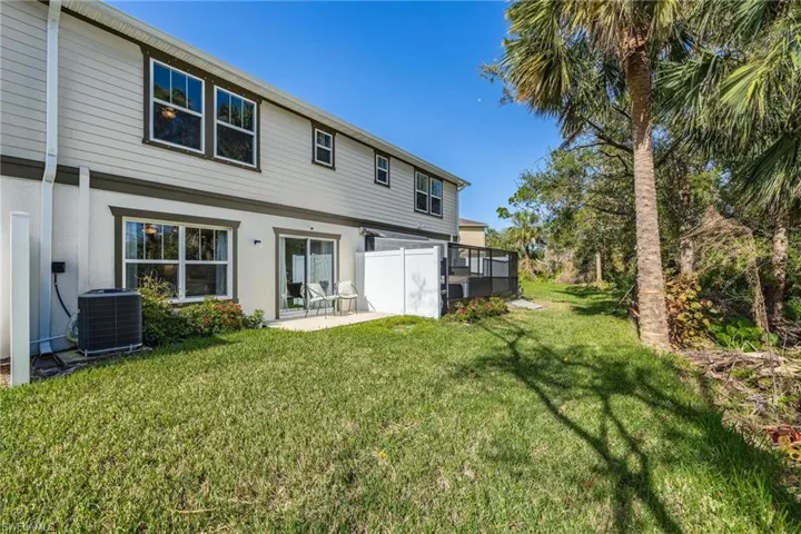Rear view of unit featuring a yard, and a lanai area